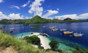 Wisatawan berfoto di atas Bukit Padar dengan panorama laut biru