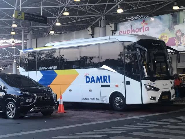 Bus DAMRI yang siap mengangkut penumpang di shelter resmi Bandara Juanda, pilihan transportasi ekonomis.