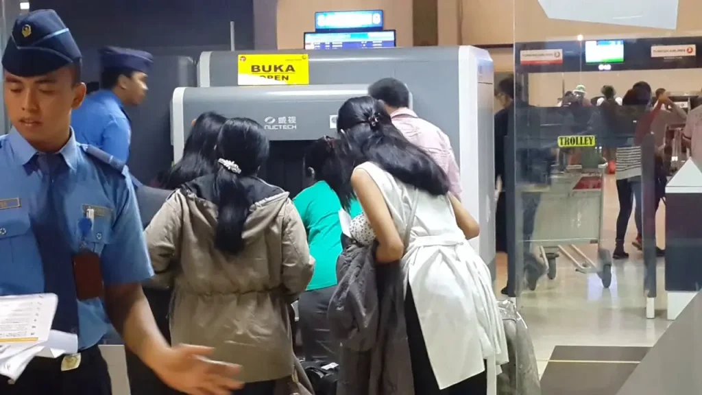 Penumpang mengantre di mesin pemindai barang bawaan pada pemeriksaan keamanan bandara