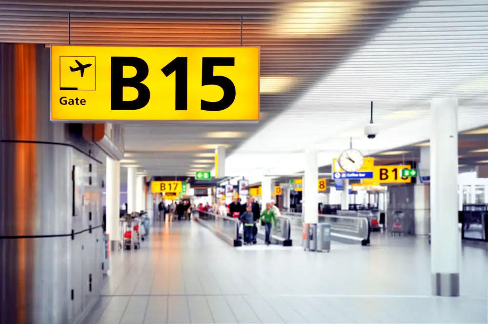 Papan penunjuk gate keberangkatan di konkors terminal bandara internasional