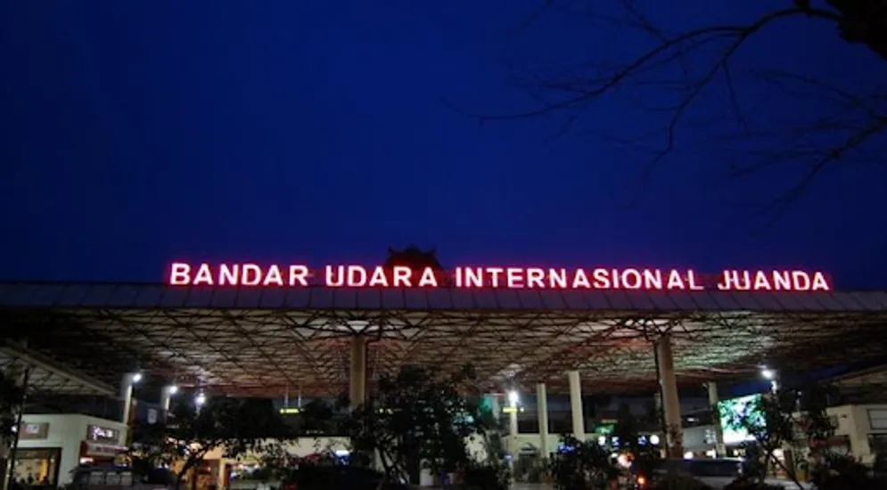 Papan nama Bandar Udara Internasional Juanda menyala pada malam hari di area kedatangan