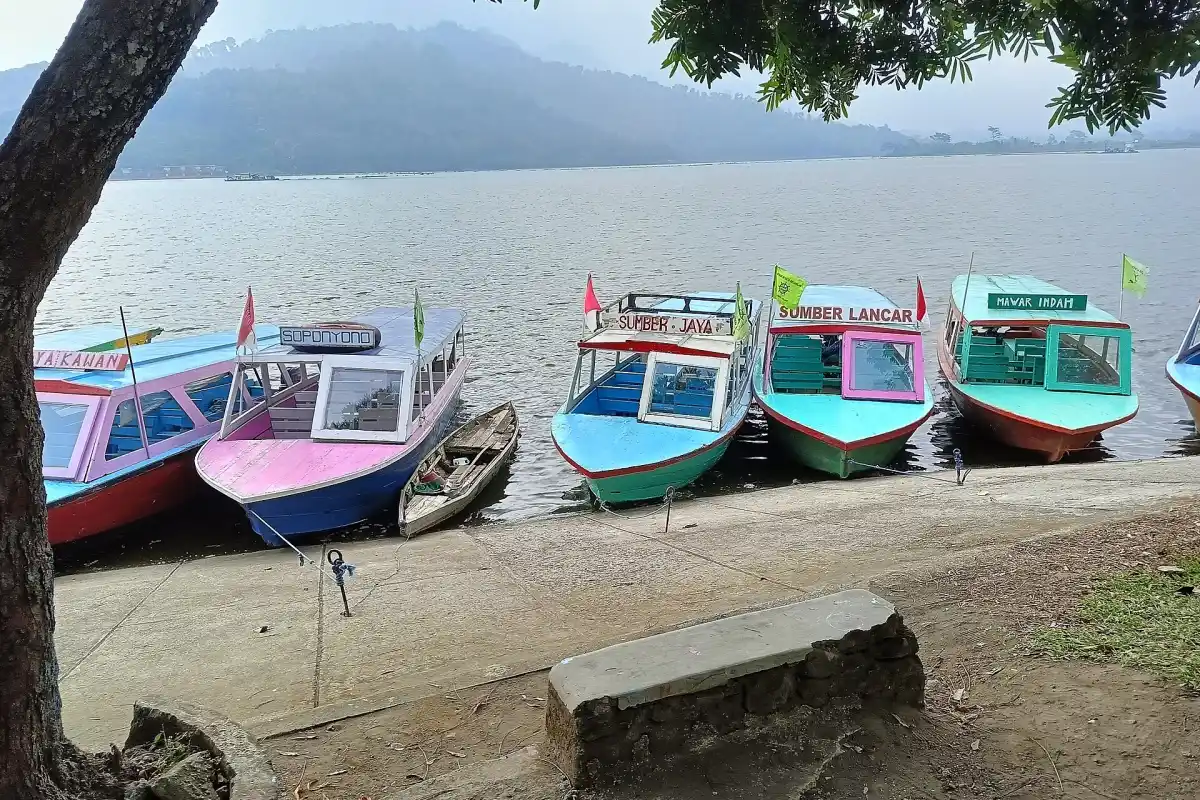 Deretan perahu warna-warni bersandar di tepi Bendungan Selorejo, Ngantang, berlatar pegunungan