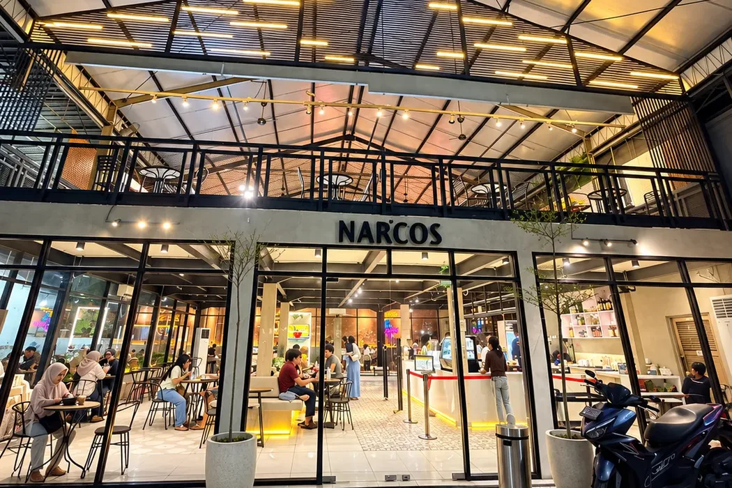 Fasad Narcos Coffee Juanda di Sedati pada malam hari dengan lampu kafe menyala dan pengunjung di dalamnya